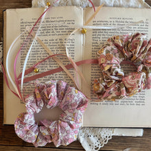 Load image into Gallery viewer, Floral scrunchies on an open book with lace and feathers