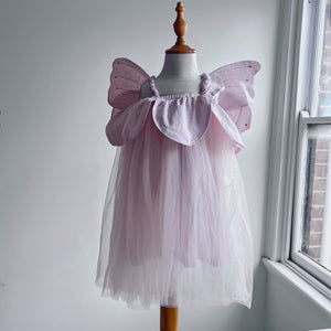 Pink fairy costume with wings on a mannequin against a neutral wall.