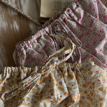 Load image into Gallery viewer, Set of floral-patterned baby bloomers on a wooden surface